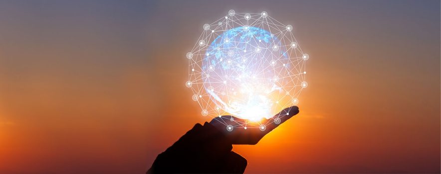 Hand holding an image of the world surrounded by a bright network of lights